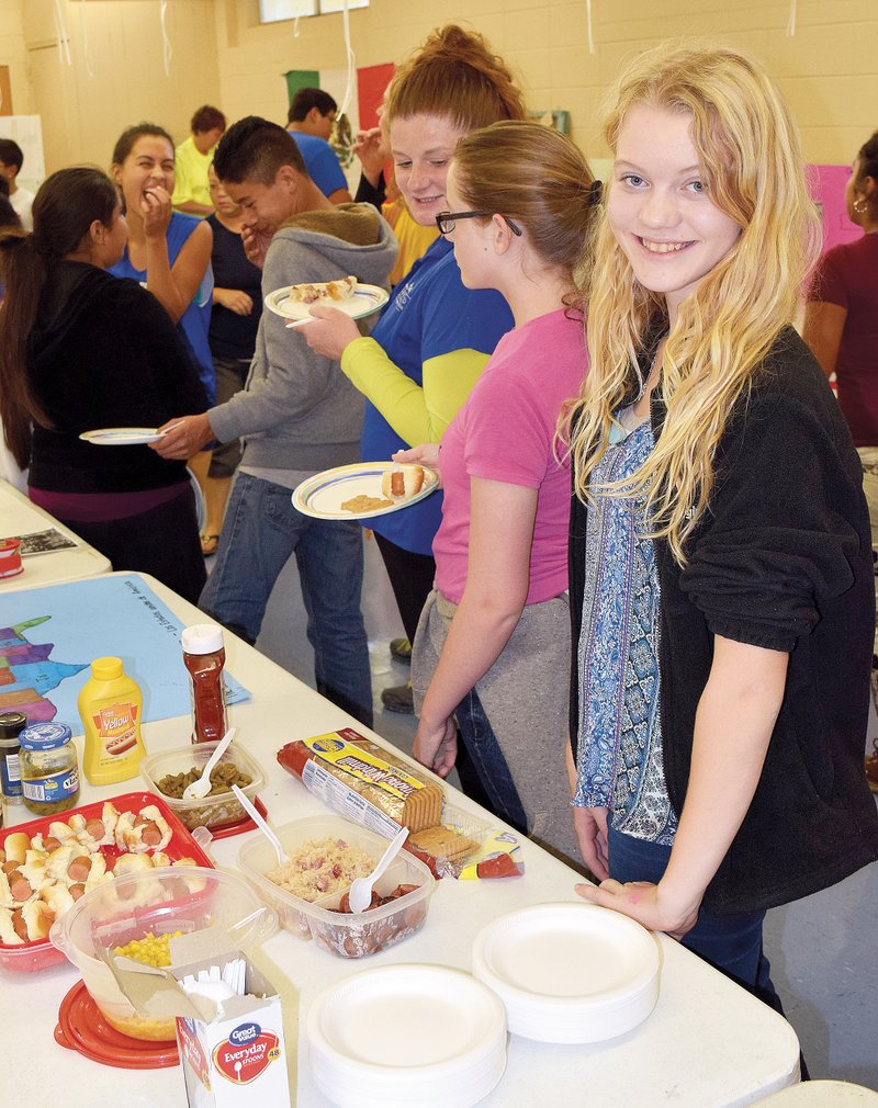 Photo by Mike Eckels Bethany Roberson (right) shows off her international food dishes during Decatur Middle School&#8217;s Multicultural Night on Oct. 29. Roberson&#8217;s dishes represented American, Native American and German Cuisine.