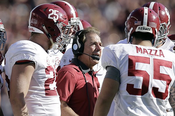 In this Oct. 17, 2015, file photo, Alabama head coach Nick Saban, center, talks to his players during the first half of an NCAA college football game against Texas A&M in College Station, Texas. (AP Photo/Eric Gay, File)