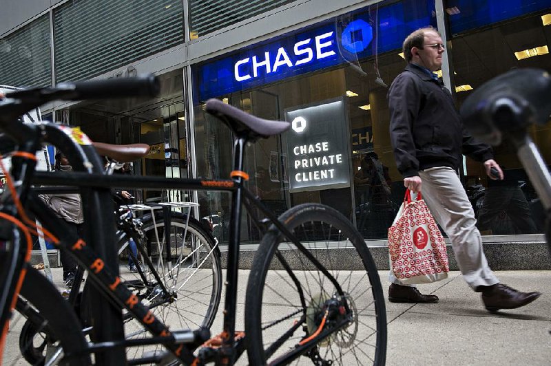 A pedestrian passes a JPMorgan Chase & Co. bank branch in Chicago in October. An annual review of U.S. banks released Thursday found loose lending standards and an increase in loans for corporate takeovers.

