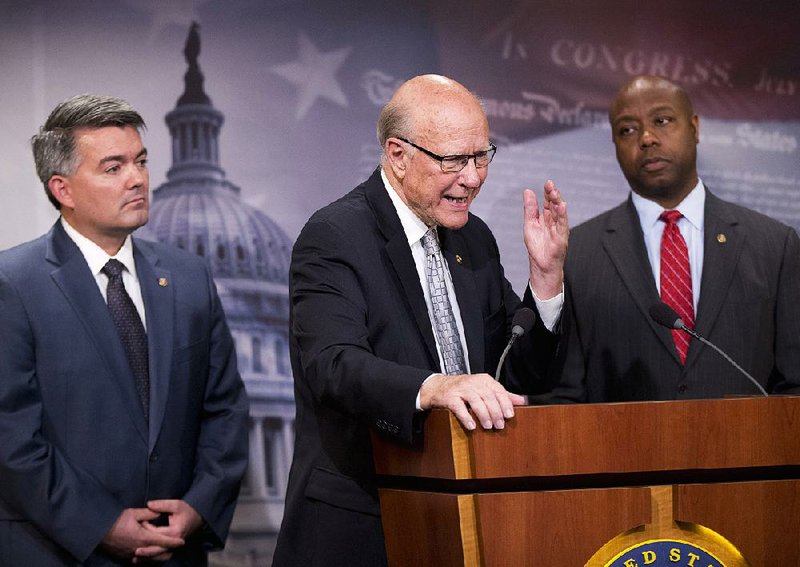 Sen. Pat Roberts, R-Kansas., center, with Sen. Cory Gardner, R-Colo., left, and Sen. Tim Scott, R-S.C., talks Thursday about provisions in the House-passed defense bill that restrict President Barack Obama’s efforts to close Guantanamo Bay.  