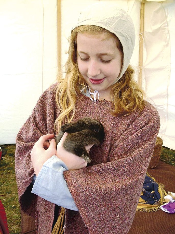 Emily Murie holds a bunny during the 2013 Renaissance Faire of the Ozarks in Fayetteville. Emily’s mother, Julie Murie, will bring her mini petting zoo — which includes rabbits — to Gravette Renaissance Festival on Saturday.