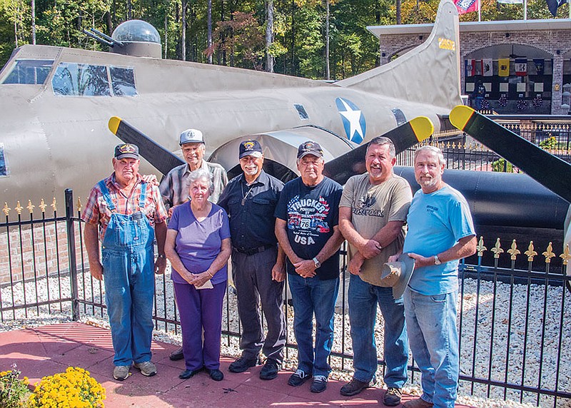 Among recent visitors to the B-17 crash site at the Grant County Veterans Memorial Park in Sheridan are, from left, Mike Harrington, Curtis McCool, Betty Tribble Barnes, Nelson Mears, Butch Davis, Don Culpepper and Gary Kelley. This replica of the plane is the centerpiece of the park, which will be the site of a Veterans Day program presented by the Grant County Chapter of Disabled Veterans at 2 p.m. Wednesday; all are invited.