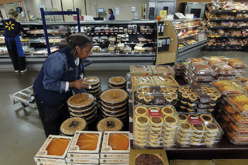 Tracy Milton, bakery department manager at the Wal-Mart Supercenter in Maumelle, sets out pumpkin pies. 