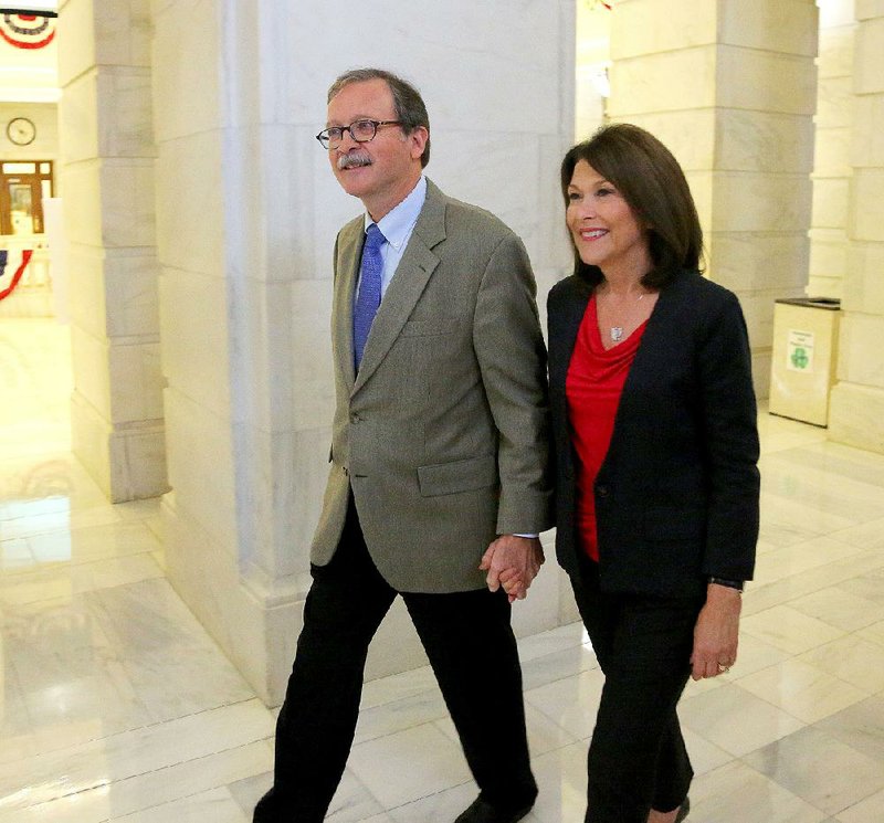 Circuit Judge Dan Kemp of Mountain View walks away Friday with his wife, Susan, after he filed at the state Capitol to run for chief justice of Arkansas. 