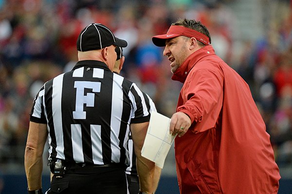 Arkansas head coach Bret Bielema, right, talks with referees during the second quarter of an NCAA college football game against Mississippi in Oxford, Miss., Saturday, Nov. 7, 2015. (AP Photo/Thomas Graning)