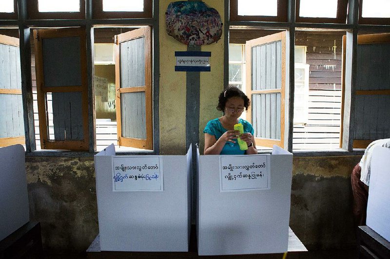 A woman casts her vote Sunday in Dala, a village outside Rangoon, Burma. More than 90 parties are represented in the elections, but the main contest is between Aung San Suu Kyi’s National League for Democracy and the ruling Union Solidarity Development Party.
