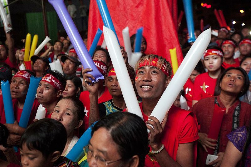 Supporters of Burma opposition leader Aung San Suu Kyi’s National League for Democracy party cheer as they watch the results of the general election on a screen displayed outside the party’s headquarters Monday in Rangoon, Burma.