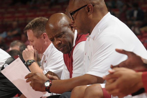Arkansas head coach Mike Anderson talks to assistant coach Melvin Watkins on the bench during the Razorbacks' exhibition game against Southwestern Oklahoma State on Thursday, Nov. 5, 2015, at Bud Walton Arena.