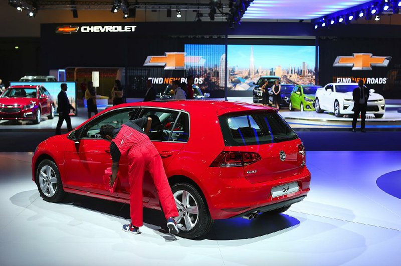 An employee polishes a VW Golf displayed at the Volkswagen AG stand during the Dubai Motor Show at Dubai’s World Trade Center, United Arab Emirates. 