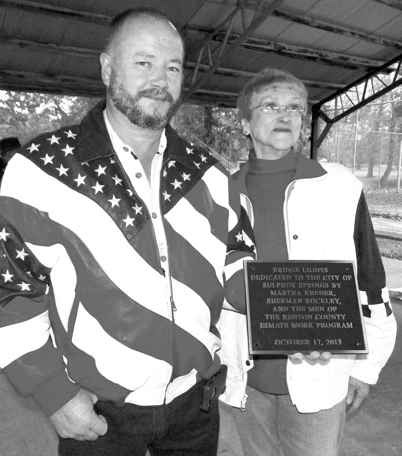 Photo by Larry Burge Mayor Greg Barber receives a plaque from Martha Kreder after her decade-long desire came true.
