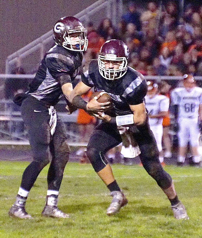 Photo by Randy Moll Jon Faulkenberry, Gentry sophomore, hands of to CJ Taylor, Gentry senior, during play between Gentry and Gravette in Pioneer Stadium on Friday, Nov. 6, 2015.