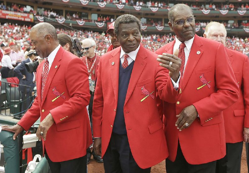 From left, in this April 8, 2013, file photo, former St. Louis Cardinals Ozzie Smith, Lou Brock and Bob Gibson are shown before the start of a baseball game between the Cardinals and Cincinnati Reds, in St. Louis. Cardinals Hall of Famer Lou Brock, a former base stealing champion, has had his left leg amputated below the knee due to an infection related to diabetes.