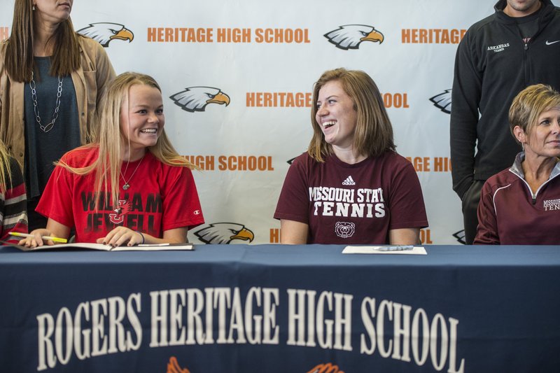 Lindsay Glynn (left) and Alye Darter both of Rogers Heritage, laugh Wednesday before signing letters of intent at the school in Rogers. Darter will play tennis at Missouri State in Springfield, Mo., and Glynn will play softball for William Jewell College in Liberty, Mo.