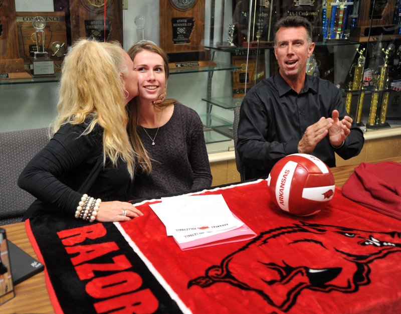 Reagan Robinson (center) with Shiloh Christian, gets congratulated Wednesday by her mother, Tiffany, and father, Simon, after signing her letter of intent to play volleyball at the University of Arkansas during a ceremony at Shiloh Christian.