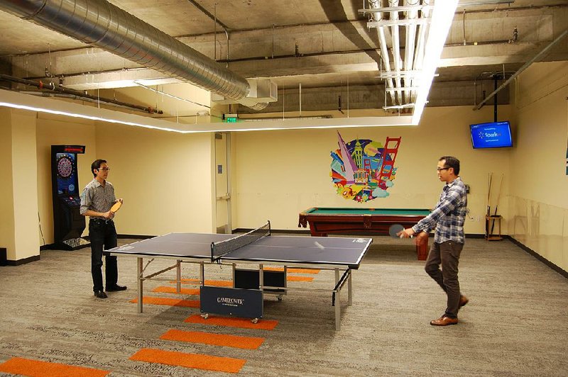 Brian Liu (left) and Matthew Mak play pingpong at Wal-Mart’s Global eCommerce offices in San Bruno, Calif. The company offers unusual perks to lure talented employees.Arkansas Democrat-Gazette/CHRIS BAHN
