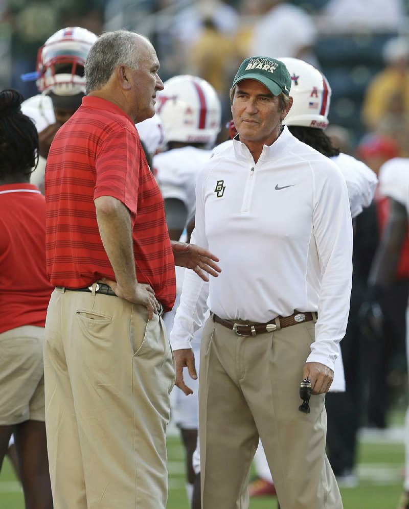 Baylor head coach Art Briles, right, and SMU head coach June Jones visit on the field before an NCAA college football game Sunday, Aug. 31, 2014, in Waco, Texas. 