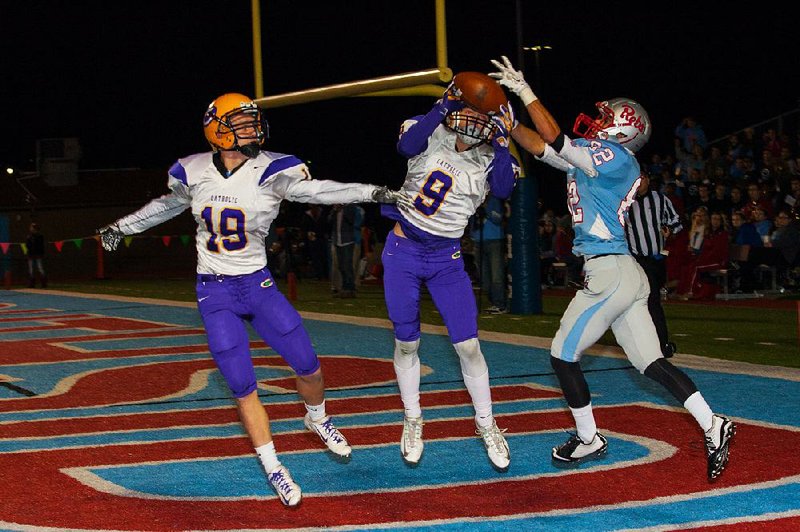 Little Rock Catholic’s Jared Allison (9) intercepts a pass intended for Fort Smith Southside’s Tanner Grandstaff in the end zone during Friday night’s Class 7A playoff game in Fort Smith. Catholic’s Peyton Adams (19) also defends on the play.