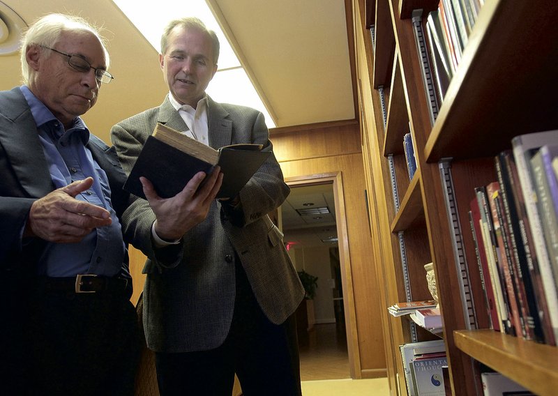 The Rev. Steve Copley (right), executive director of Interfaith Arkansas, and board member Bruce Diggins (left), browse through books at the new interfaith library at First United Methodist Church in downtown Little Rock. An open house will be held Sunday.