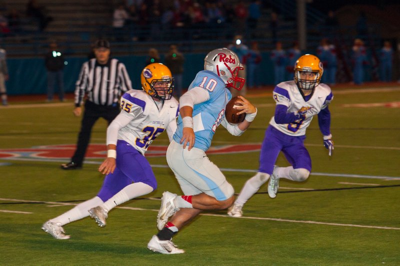 Josh Pinter (left) and Zach Gee of Little Rock Catholic try to run down quarterback Cooper Johnson of Fort Smith Southside during the first quarter in Fort Smith.