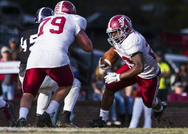 Henderson State running back Jaquan Cole (23) runs behind the block of offensive lineman Justin Carpenter (79) during Saturday’s game against Ouachita Baptist. The Reddies beat the Tigers 21-17 to win their ninth consecutive game.