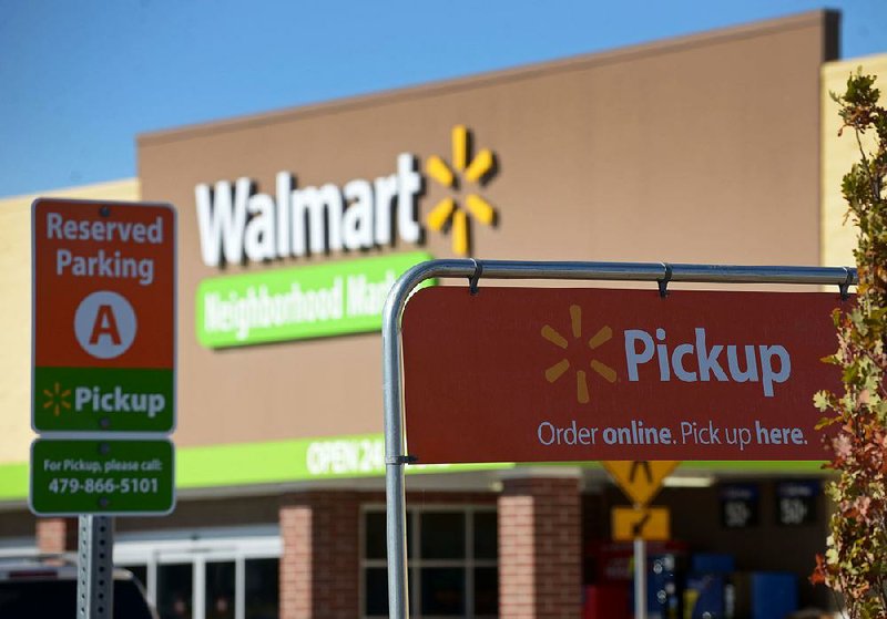 Signs designate parking spaces for grocery pickup at the Wal-Mart Neighborhood Market in Bentonville. 
