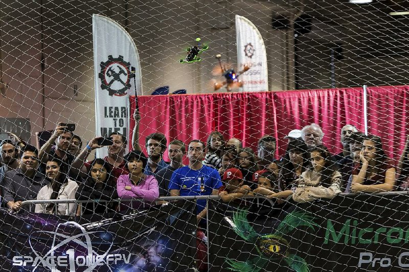 Drones fly by spectators at the California Cup races in Pomona, Calif., on Nov. 7. The fast-moving quadcopters are hard to follow. “It’s like watching two hummingbirds zip around the yard,” said Keith Robertson, a drone racer from Palos Verdes, Calif. 