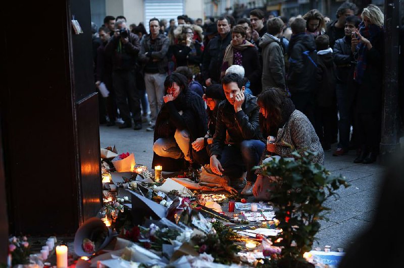 Mourners put flowers Saturday outside the Le Carillon bar in Paris in the area where attackers targeted several nightspots Friday. 