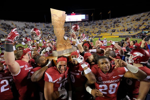 Arkansas players celebrate with the boot after defeating LSU on Saturday, Nov. 14, 2015, in Baton Rouge, La.