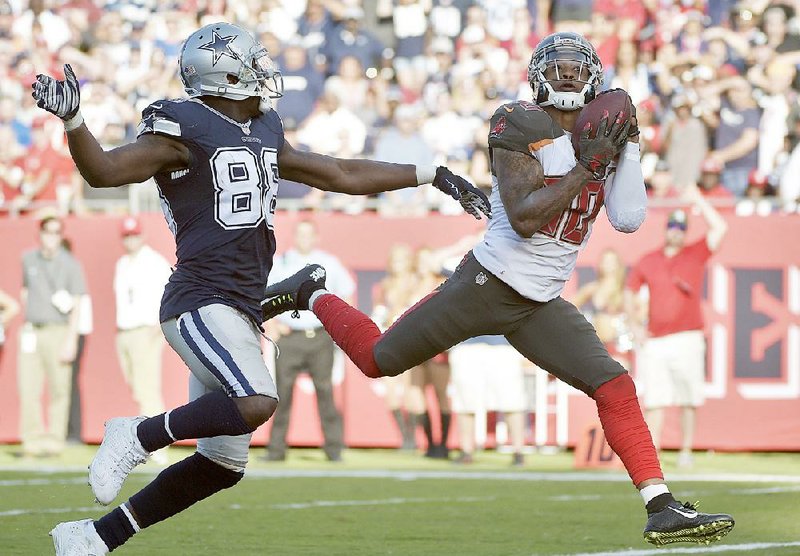 Tampa Bay safety Bradley McDougald (30) grabs a game-clinching interception behind Dallas wide receiver Dez Bryant to give the Buccaneers a come-from-behind, 10-6 victory Sunday and send the Cowboys to their seventh loss in a row. 
