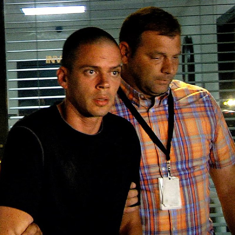  Suspect Arron Lewis (L) is escorted from the Pulaski County Sheriff's department by investigators after being interrogated, September 30, 2014.