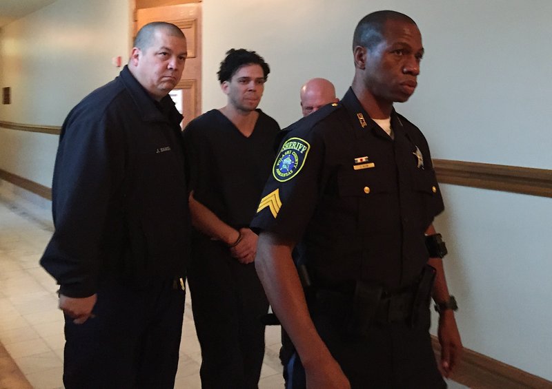 Arron Lewis is escorted into court Monday morning.