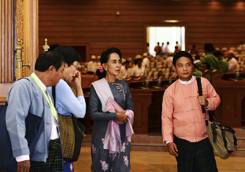 Burma’s opposition leader Aung San Suu Kyi (center) leaves a regular session of the parliament Monday in Naypyitaw, Burma.
