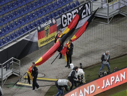 German flags are carried out of the stadium as the soccer friendly between Germany and the Netherlands was canceled in Hannover, Germany, on Tuesday, Nov. 17, 2015.