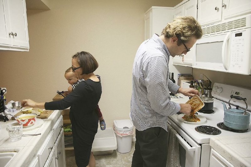 Jakub Zielkiewicz (right), Aimee Barnes and their 15-month-old son, Roman, are shown in their home in Sacramento, Calif. A Pew Research Center survey captures how working parents are feeling shorted on personal time, and the data show that while family structure seems to have changed, public policy, workplace structure and mores have not adjusted to a norm in which both parents work. 