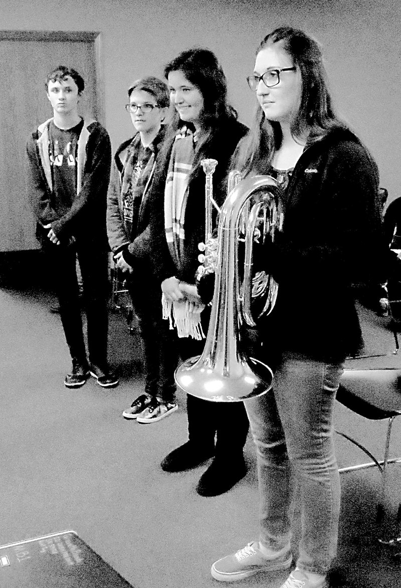 Photo by Susan Holland The four members of the Gravette Band Council attended the November Gravette School Board meeting and led the Pledge of Allegiance to open the meeting. They are Wesley Hearne, freshman representative, left; Brooke Brasel, sophomore representative; Micah Wallace, junior representative; and Kaylea Turner, senior representative. Kaylea displays one of the new instruments the band recently received.