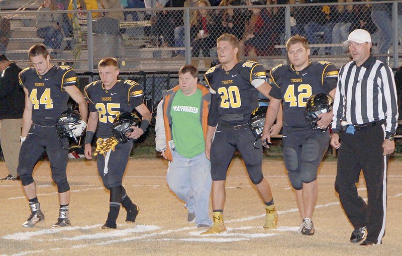SUBMITTED BY SHELLEY WILLIAMS Captains for the Prairie Grove Tigers for Friday&#8217;s game go to the middle of the field for the coin toss: Coty Hoskins, left, Cole McClellan, Blake Faulk and Cole Walker. Walking in the center with the players is one of Prairie Grove&#8217; most enthusiastic fans, Raymond Montgomery.