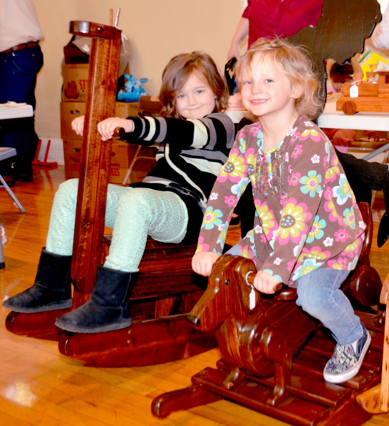 Janelle Jessen/Herald-Leader Fayth Horn and Maddy Carter, both 5, tried out a rocking giraffe and dachshund made by Keith Brosch Design.