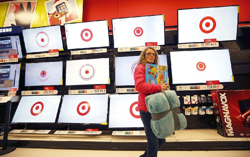 A customer passes flat-screen TVs at a Target store in South Portland, Maine, in this file photo. The retailer Wednesday reported a net profit of $549 million, reflecting the elimination of losses from its now-closed Canadian stores. 