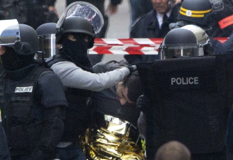 French police officers detain a suspect after a raid early Wednesday in the Paris suburb of Saint-Denis that officials say thwarted another attack. Residents were awakened by explosions and gunfire as police blasted their way into an apartment building. 