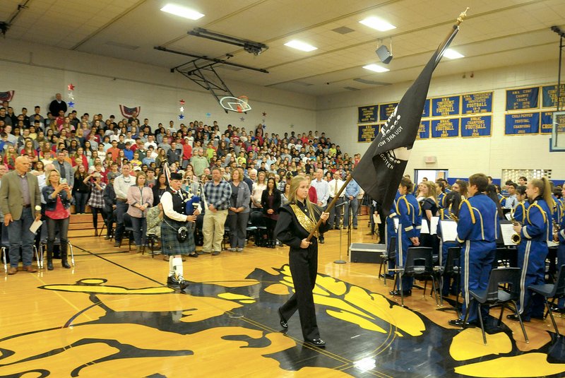 Raegan Couch, a ninth-grader and drum major at Central Junior High School in Springdale, carries the POW-MIA flag Nov. 10 before posting it during the 20th annual Veteran's Day Assembly in the school gym. The assembly featured music from the school's band and choral groups as well as speakers and recognition of veterans.