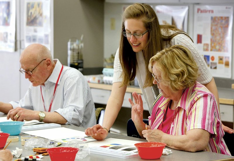 Leana Fischer (center), teaching artist at the Community Creative Center at the Walton Arts Center’s Nadine Baum Studios, works with Jan Ainsworth of Fayetteville on blending colors during the Osher Lifelong Learning Institute’s Spring into Watercolor two-day watercolor workshop at the center in April. The center’s holiday gift market will be available in the Joy Pratt Markham Gallery at the Walton Arts Center during all holiday performances.