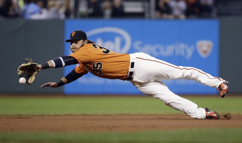  This Friday, Sept. 18, 2015 file photo San Francisco Giants shortstop Brandon Crawford makes a diving attempt at a ground ball by Arizona Diamondbacks' Paul Goldschmidt during the first inning of a baseball game in San Francisco.