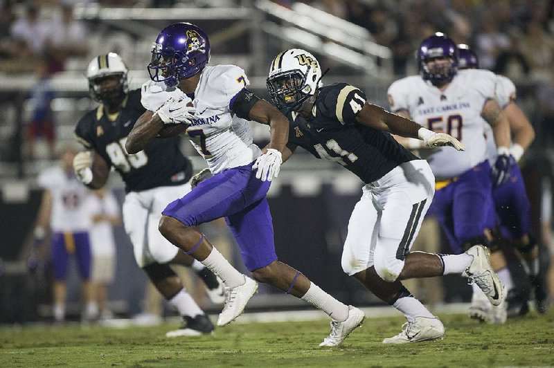 East Carolina wide receiver Isaiah Jones (7) gains yards after a catch as he runs by Central Florida linebacker Demeitre Brim (44) during the Pirates’ 44-7 victory over the Knights on Thursday in Orlando.