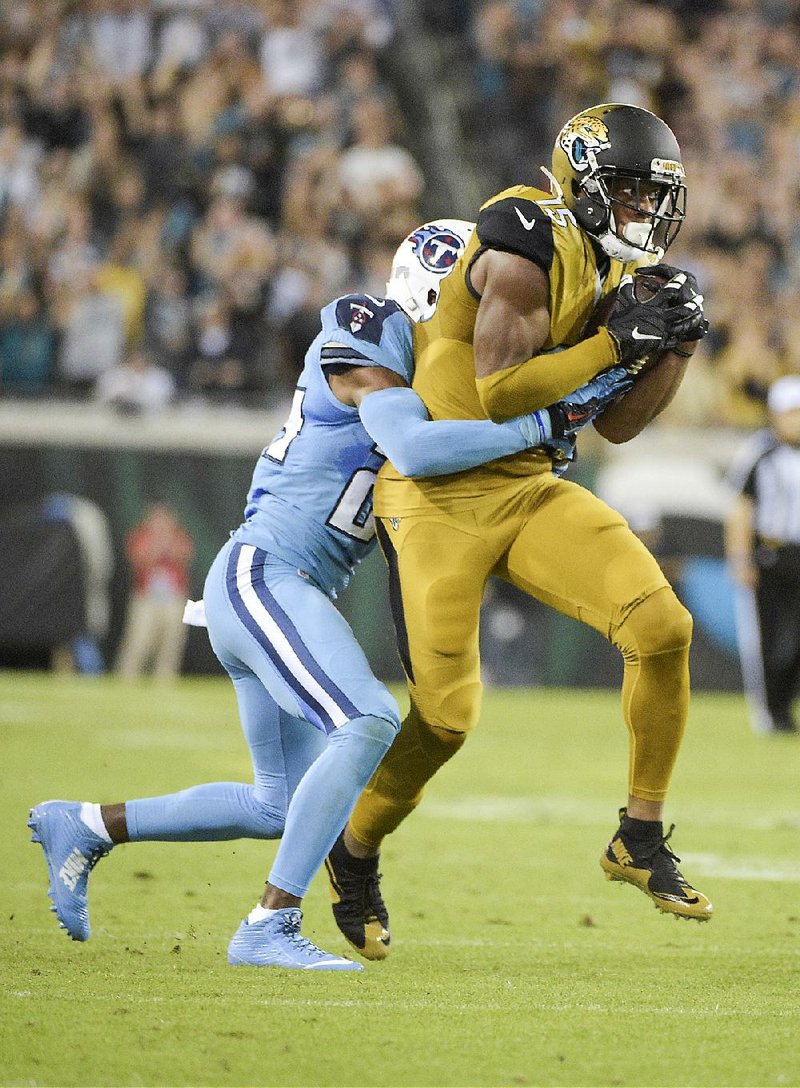 Jacksonville Jaguars wide receiver Allen Robinson (15) makes a catch in front of Tennessee Titans cornerback Coty Sensabaugh (24) during the first half Thursday in Jacksonville, Fla.
