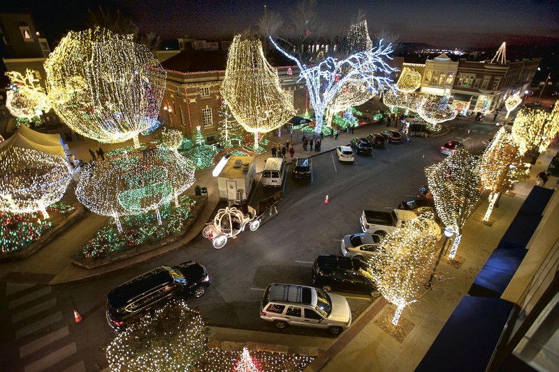 Traffic and pedestrians pass check out the Lights of the Ozarks display Wednesday, Nov. 26, 2014, on the Fayetteville square.