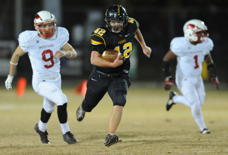 Cole Walker (42) of Prairie Grove carries the ball Nov. 13 ahead of Demarius Smith (9) of Jonesboro Westside at Tiger Stadium in Prairie Grove. The Tigers (10-1) host Ashdown in a second-round playoff game tonight. Visit nwadg.com/ photos to see more photographs from the game.

