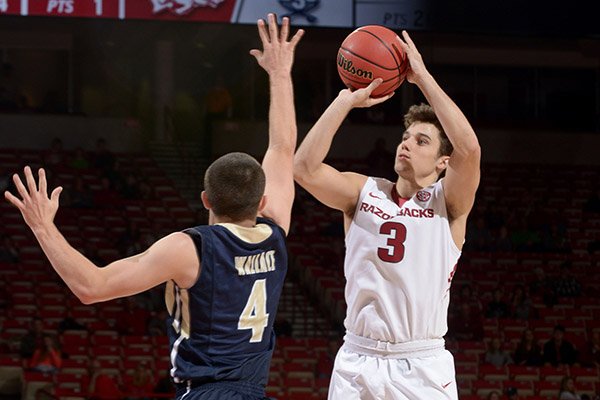 Dusty Hannahs of Arkansas sinks a 3-point basket over Patrick Wallace of Charleston Southern on Friday, Nov. 20, 2015, during a game in Bud Walton Arena in Fayetteville.