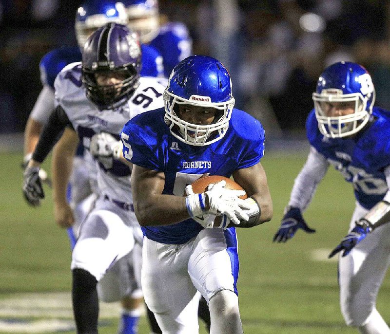 Bryant’s De’amonte Terry runs away from Fayetteville’s Luke Rhoads during Friday night’s Class 7A playoff game in Bryant. See more photos on arkansasonline.com/galleries