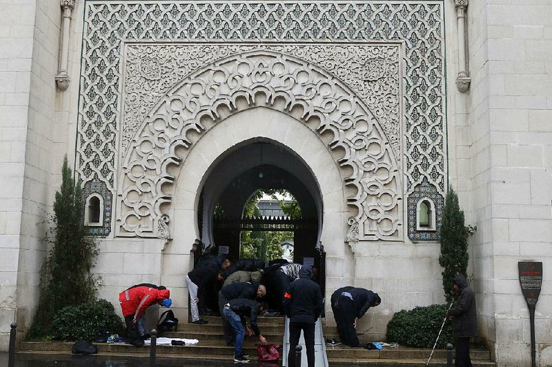 Worshippers pray Friday at the entrance of the Great Mosque of Paris one week after the terrorist attacks. France called on its European Union partners to take quick action on border security to keep out extremists.