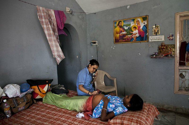 A nurse performs a checkup on a surrogate mother in a dormitory in Anand, India, in November. 